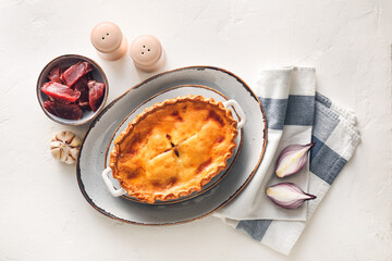 Tasty beef pot pie with ingredients on white background
