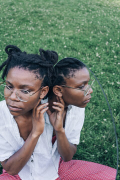 Conceptual portrait of a woman in park with the mirror 