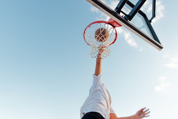 Boy dunking basketball.