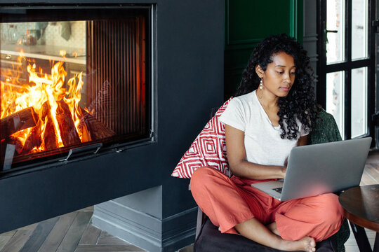 Focused black woman working near fireplace