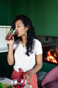 Content black woman testing fresh smoothie