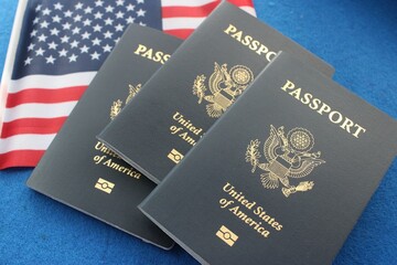 Three US passports with American flag, on blue background