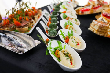 Portion snacks on a buffet table in ceramic dishes