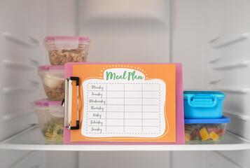 Containers with healthy food and clipboard with meal plan in refrigerator