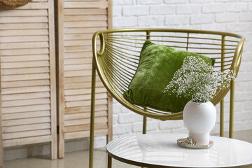 Vase with beautiful gypsophila flowers on table in room