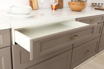 Opened kitchen drawer and utensils in room