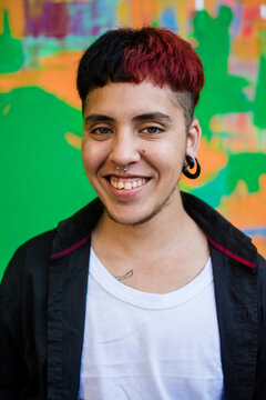 Young latino man portrait over green jaded wall