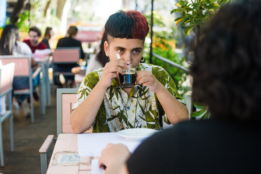 Latino queer gen z having coffee and listening his mom
