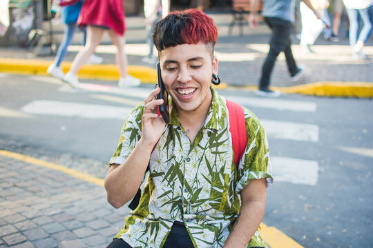 Young latino man talking on the phone and smiling
