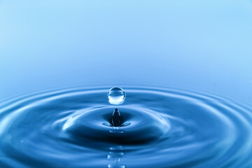 Naklejka na ściany i meble Splash of water on blue background