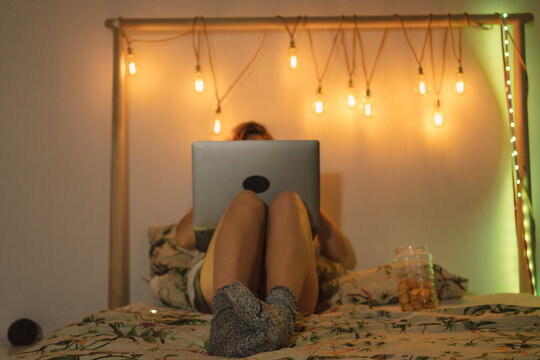 Female with laptop on the bed 