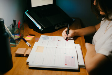 Female writing notes in her weekly planner at room