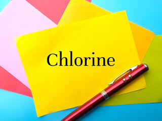 Pen with colorful paper with text Chlorine on a blue background.