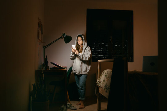 Teen female using her phone at night