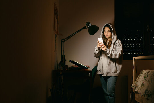 Teen woman texting at bedroom