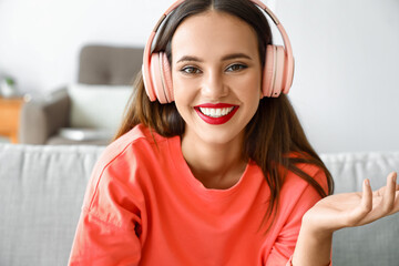 Beautiful woman in headphones video chatting at home