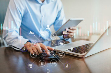 Male businessman or Designer using tablet with laptop and document on desk in modern office with virtual interface graphic icons network diagram.