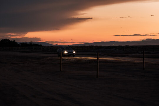 car on deserted road at sunset