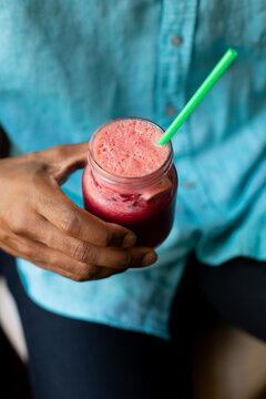 Young Man Drinking A Strawberry Smoothie