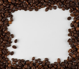 frame made of coffee beans on a white background. Frame made from roasted coffee beans over white background with room for text or image