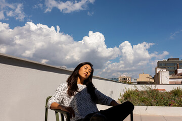 Woman relaxing on sunny rooftop