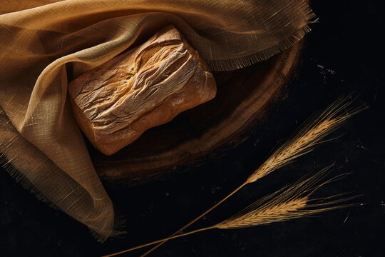 Golden ciabatta with wheat ears on a wooden table. Fresh delicious traditional Italian bread. Concept of healthy food and bakery.
