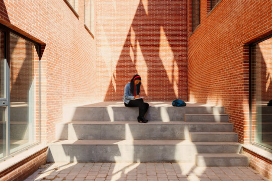 Woman studing on building stairs