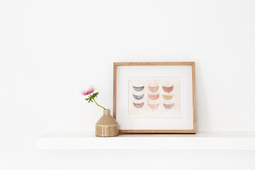 Framed artwork on floating shelf