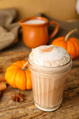 Glass of tasty pumpkin latte on table