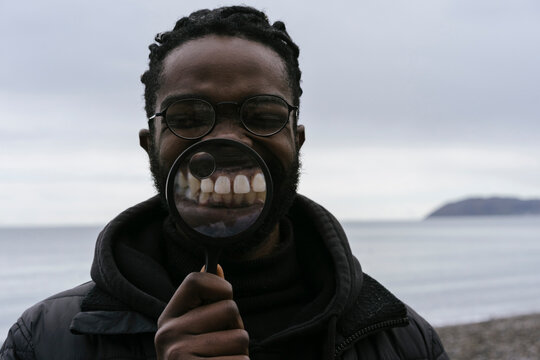 Black Man is Playing with a Magnify Glass