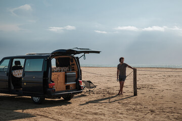 Obraz premium Man camping on beach with van 