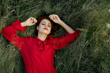 woman in red dress lies on the grass nature freedom summer