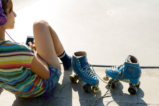 Woman listening to music while resting from skating