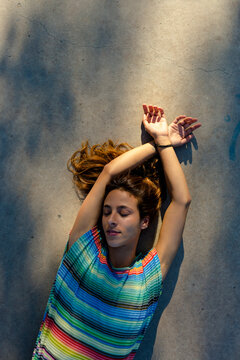 Woman laying down on the ground with closed eyes