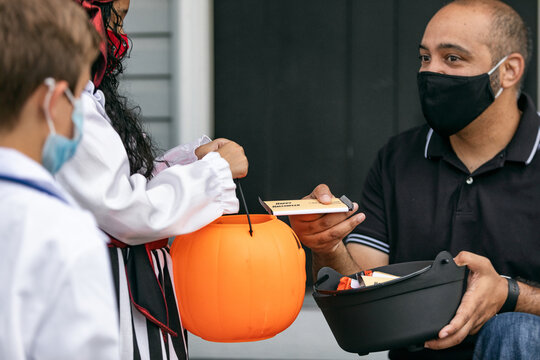 Halloween: Adult With Mask Hands Out Candy To Kids