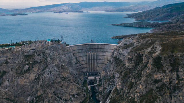 Arch-gravity dam in mountains, aerial view