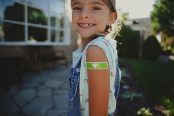 Young girl shows off bandaid from her vaccine shot