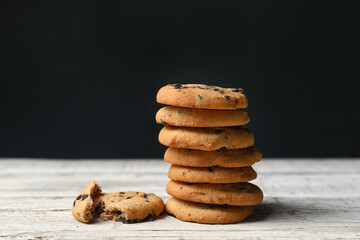 Stack of tasty cookies with chocolate chips on light wooden table