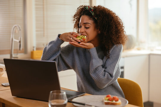 Black freelancer having breakfast during work