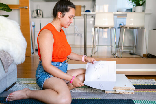 Woman self-assembling furniture at home