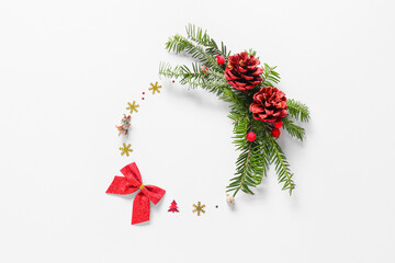 Beautiful wreath made of fir branches and Christmas decor on light background