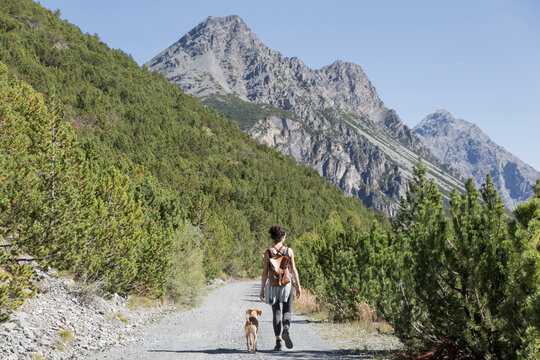 trekker girl with dog on mountain pathway