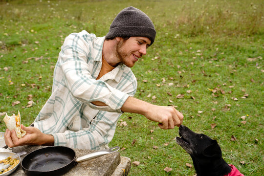 Man having picnic outdoors with his dog