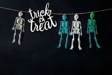  Trick or treat sign with four  skeletons hanging with string