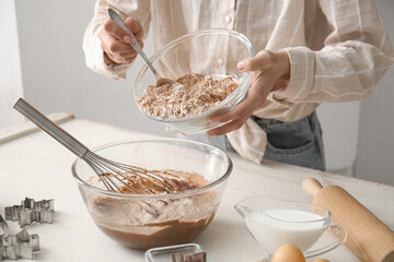 Woman preparing chocolate dough at kitchen table, closeup