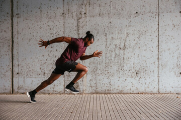 African American athlete sprinting on street