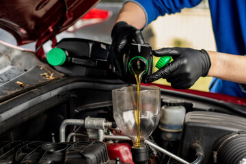 Fototapeta na wymiar Changing replacement car oil with plastic bottle. DIY change engine motor oil. At home vehicle maintenance. Garage mechanic
