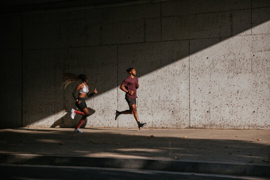 African American athletes running in shadow