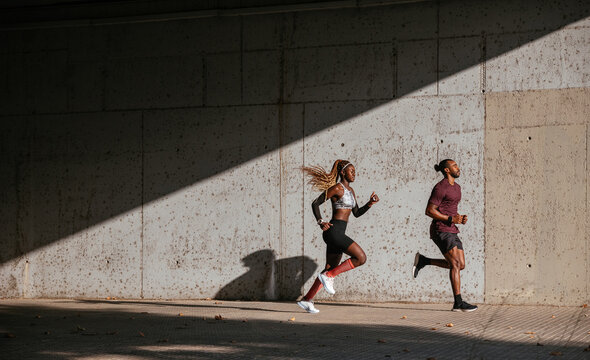 Black athletes running on street