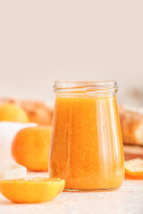 Jar of tasty tangerine jam on table, closeup